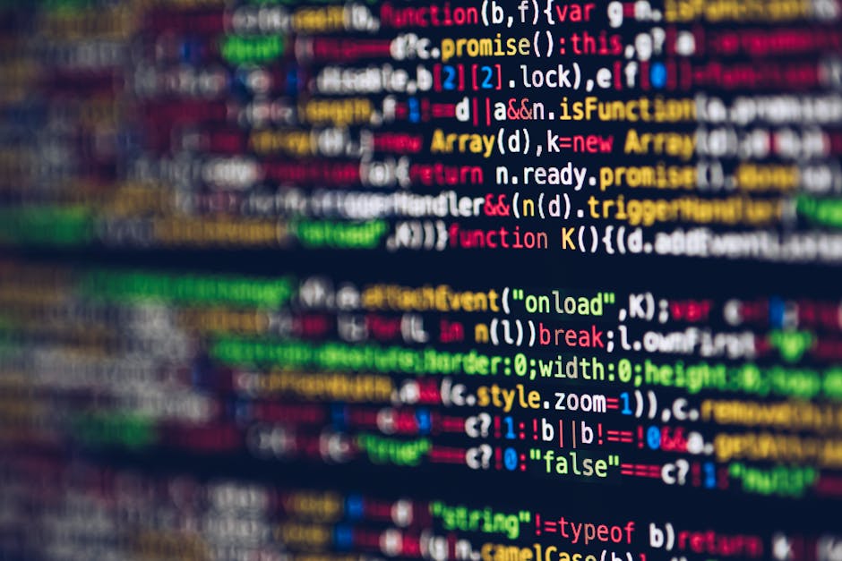 A close-up view of a computer screen displaying colorful lines of programming code in various shades of red, blue, green, yellow, and white on a dark background. The code features typical syntax eleme